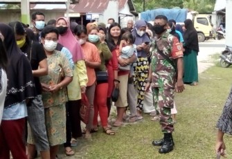 Babinsa Koramil Bukit Batu saat Awasi dan Pantau Operasi Pasar Sembako Murah Warga Tumbang Tahai 