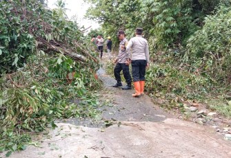Petugas saat cek lokasi dan berusaha membersihkan material longsor dibantu warga setempat