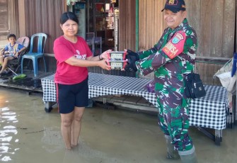 Babinsa saat turut salurkan Makanan Kepada Warga Terdampak Banjir 