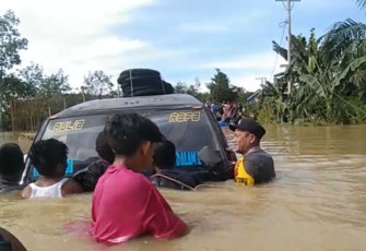 Bhabinkamtibmas Polsek Ranto Peureulak saat Berjibaku Membantu Evakuasi Mobil Terseret Banjir