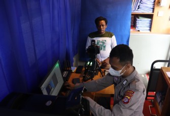 Petugas Ditlantas Polda Kalteng saat membuatkan SIM gratis untuk  Tukang Ojek dan Pedangan Sayur Keliling