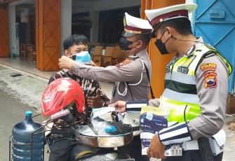 Personil Satlantas Polres Karanganyar saat membagikan masker gratis di  kawasan simpang empat Jalan Lawu, Papahan, Tasikmadu, Karanganyar, Kamis (3/2/2022)
