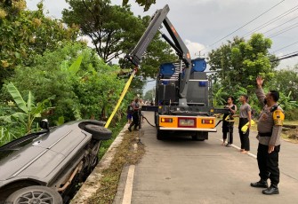 Tim SAR Samapta Polres Karanganyar, saat melakukan evakuasi mobil yang terperosok ke dalam selokan