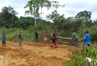Satgas Yonif 144/JY Benahi Jalan Berlobang Bersama Warga