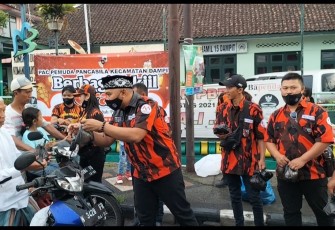 Ketua PAC PP Dampit, H. Nanang Qosim, saat membagikan takjil kepada pengguna jalan, Sabtu (30/4/2022)