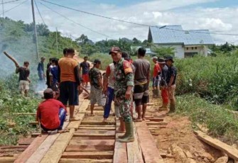 Berjibaku bersama warga benahi jalan desa menggunakan papan kayu. Minggu (15/05/2022)