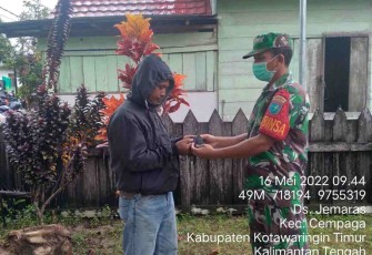 Sertu Marben bagikan masker ke warga yang melintas di jalan. Senin (16/05/2022)