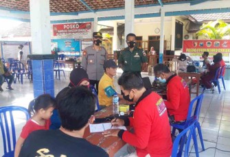 Personel Kodim 0803/Madiun mendampingi warga vaksinasi. Kamis (19/05/2022)
