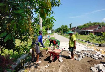 Bantu warga pasang paving jalan di desa binaan