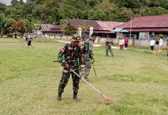 Satgas perbatasan potong rumput lapangan sepak bola