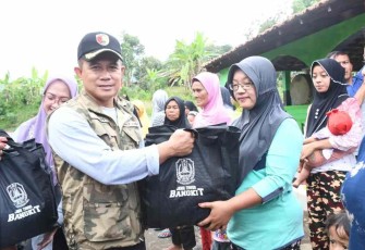 Danrem 081/DSJ Kolonel Inf Deni Rejeki saat memberikan bantuan sembako warga. Minggu (1/10)