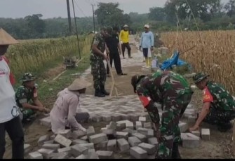 Pemasangan paving jalan desa binaan