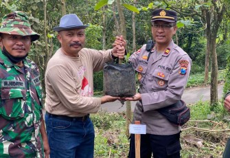 Kapolsek Junrejo Iptu Anton Hendri saat pelaksanaan tanam pohon mangga dan alpukat di desa Tlekung Kota Batu, Minggu (4/12)