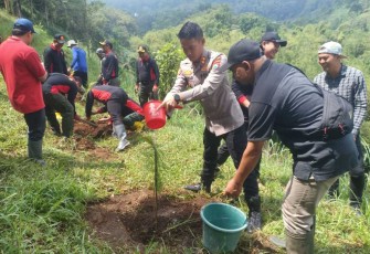 Kapolres Batu AKBP Oskar Syamsuddin saat menyiram bibit pohon pinus
