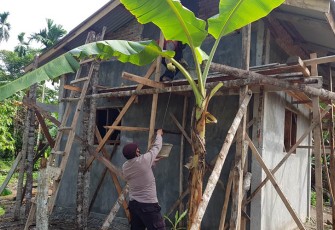 Dua anggota Polsek Pantee Bidari Polres Aceh Timur Aipda Deni Ariansyah dan Brigadir Desri Permana Putra yang turut membantu warga Desa Seunebok Tuha membangun rumah, Rabu (30/11/2022).