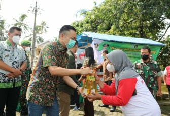 Wabup Rahmat Saat Melayani Masyarakat Pembeli Minyak Goreng di Operasi Pasar Minyak Goreng yang Dilaksanakan di Area Parkir Wisata Kolam Renang Penataran