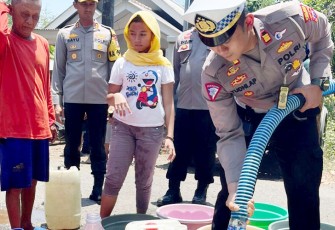 Satlantas Polres Pasuruan saat mendistribusikan Air Bersih pada warga di Kab. Pasuruan