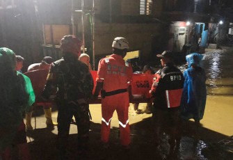 Petugas dan warga bergotong royong angkat perahu karet 