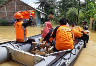 Petugas BPBD setempat saat evakuasi warga terdampak banjir menggunakan perahu karet