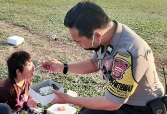 Bhabinkamtibmas Polsek Kembangan saat suapi makanan kepada Anak Berkebutuhan Khusus