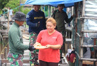 Yeni Septiana (34) saat menunjukan rasa terima kasihnya kepada TNI dengan memberikan makanan ringan berupa kue kepada personel TMMD ke 115