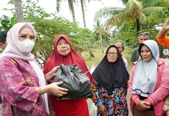 Ketua TP PKK Derta Wahyulin Rohidin saat bantu sembako kepada keluarga di dua RT yang terdampak banjir akibat luapan sungai Bengkulu.