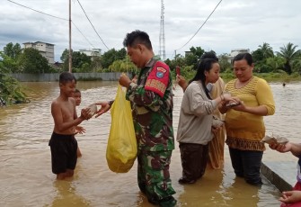 Babinsa Koramil Tewah saat Bagikan Nasi Bungkus Pada Warga 
