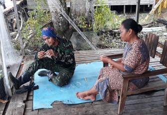 Anggota Satgas TMMD saat Bantu Membuat Perangkap Ikan Warga Petuk Katimpun 