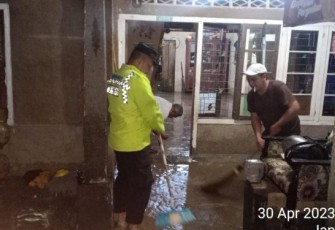 Bhabinkamtibmas Polsek Batang Angkola, Bripka Tommy Harianto, SH, tampak hadir menolong saat Rumah warga terendam banjir lebih kurang 30 Cm, pada Minggu (30/4/2023) malam