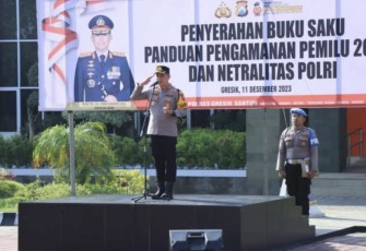 Kapolres Gresik AKBP Adhitya Panji Anom menyerahkan secara simbolis buku saku panduan pengamanan pemilu 2024 dan netralitas Polri kepada perwakilan personel di halaman Mapolres Gresik, Senin (11/12/2023)