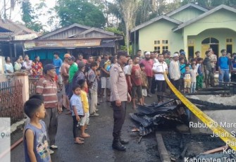Petugas Polsek Sipirok memasangi garis polisi di lokasi kejadian Kebakaran.