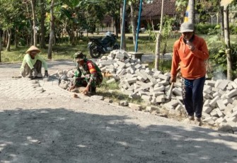 Babinsa saat Bantu Warga Pasang Paving