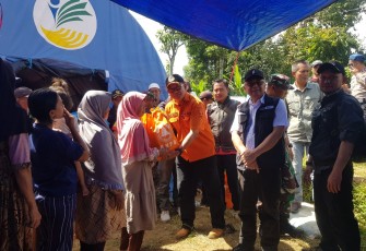 Wakil Bupati Sukabumi Iyos Somantri (baju putih rompi hitam) dan Sekretaris BPBD Kabupaten Sukabumi Yudistira (baju orange) menyerahkan bantuan sembako kepada warga terdampak gempa di Kabupaten Sukabumi, Jawa Barat pada Kamis (14/12)