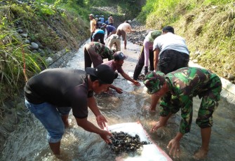 Babinsa Koramil Dagangan Bantu Warga Bersihkan Saluran Irigasi