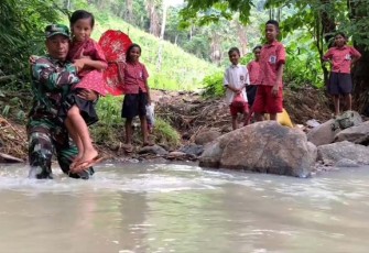 Babinsa di Larantuka saat Bantu Anak Sekolah Seberangi Sungai