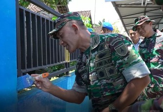 Danrem 081/DSJ Kolonel Inf Deni Rejeki saat mengecet pagar