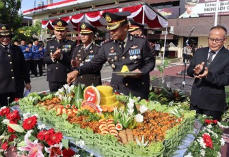 Kapolrestabes Medan Kombes Valentino Alfa Tatareda saat memotong tumpeng HUT Bhayangkara ke 77