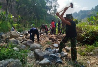 Pecahkan batu bangun pondasi jembatan di lokasi TMMD Kodim Madiun 