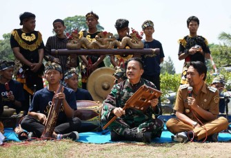 Irdam V Brawijaya Brigjen TNI Abdul Rachman saat mencoba alat musik Dongkrek disela penutupan TMMD Kodim 0803/Madiun, Kamis (10/8)