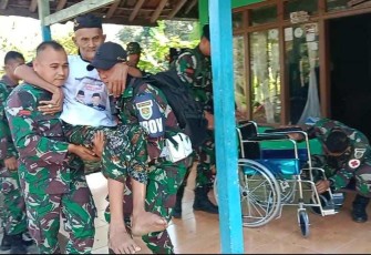 Veteran RI bapak Jaya dibopong saat menerima kursi roda dari Yonif Raider 301/PKS