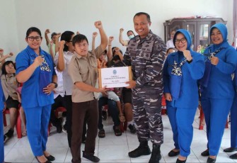Danlanudal Manado Letkol Laut (P) Tatang Yanuar Ristanto saat memberikan bingkisan, Kamis (24/8) 