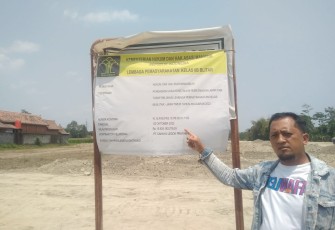 Salah Seorang Tokoh Masyarakat Setempat Saat Menunjukkan Papan Profil Pengerja Proyek Relokasi Lapas Kelas II B Blitar