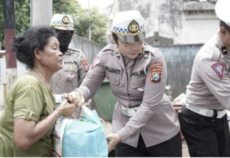 Personel Ditlantas Polda Jatim saat membagikan bingkisan