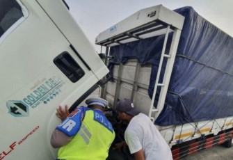 Anggota PJR Polda Jatim saat membantu perbaiki truk mogok di tol Jombang Mojokerto KM 683/B, Rabu (10/5)