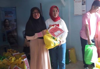 Kadis Lingkungan Hidup jilbab merah saat memberikan paket sembako kepada warga