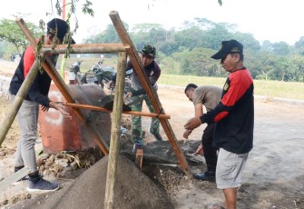 "Tampak anggota satgas TMMD Reg ke-117 Kodim Karanganyar, bersama dengan wargasedang mengayak pasir"