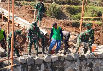 "Satgas TMMD bersama warga sedang mengerjakan pembuatan jembatan yang merupakan sasaran fisik TMMD Reg ke-117"