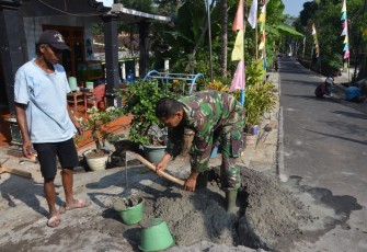 "Satgas TMMD Reg ke-117 desa Gentungan sedang mengaduk semen dan pasir"