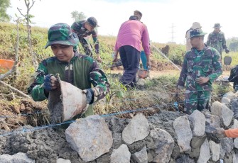 "Satgas TMMD Reg ke-117 desa Gentungan sedang membangun talud jalan sebagai sasaran fisik TMMD"