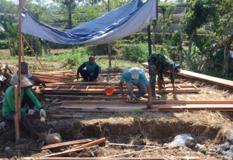 "Anggota Satgas TMMD sedang menyiapkan papan cor"